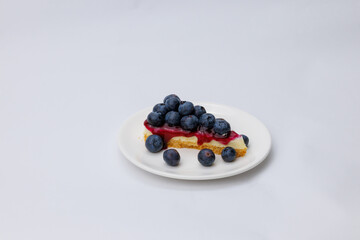 Start your morning right with a luscious blueberry sheet cake, crowned with fresh blueberries and served alongside rich black coffee.