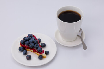 Start your morning right with a luscious blueberry sheet cake, crowned with fresh blueberries and served alongside rich black coffee.