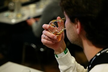 Enjoying a fine whiskey at a bustling tasting event during the evening