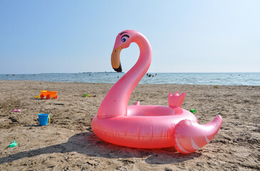 Pink flamingo floater on the beach