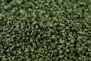 Close-up view of small, dark green, cubic particles