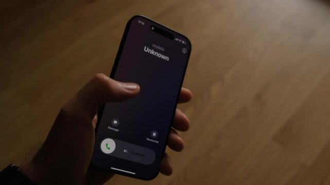 Fraud or fraudulent schemes. Close-up of a male hand holding a phone with an unexpected incoming call from an unknown