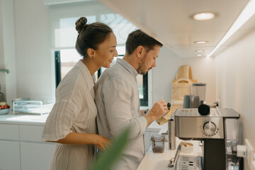 A couple is making coffee in the kitchen