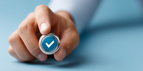 Confirming Choice: A hand delicately holds a metallic blue button featuring a prominent white checkmark, symbolizing confirmation, selection, or approval.