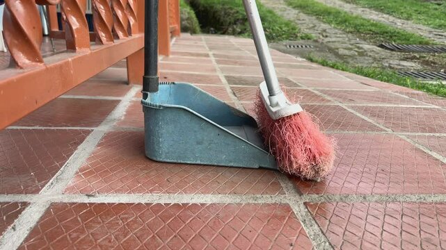 Escoba y recogedor para barrer el piso de una casa en el campo