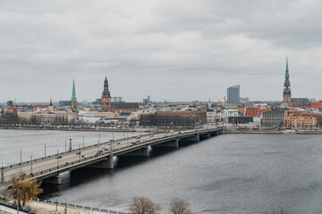 Riga big bridge for cars over large river that divides city coasts. City scape of riga buildings...