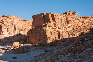 A rocky hillside with a large rock in the foreground
