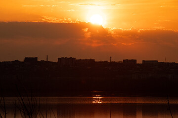 Sunset over the embankment of the city of Dnieper in Ukraine with reflections of the sun on the water