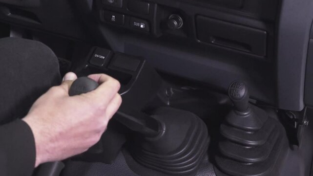 Close-up of a man's hand pressing the accelerator in a car.