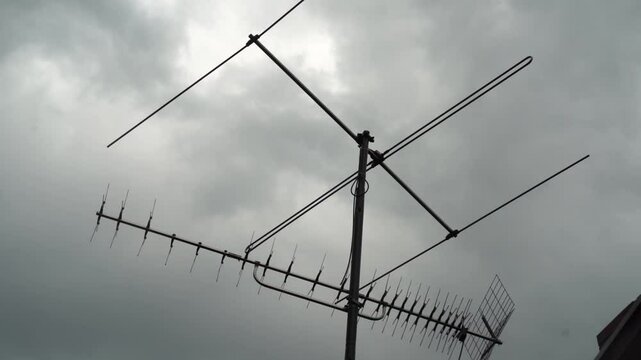 Slow storm clouds brewing above antenna as storm lightning rod be careful as dangerous weather arrives