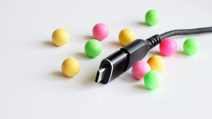 Close-up of black USB Type-C OTG adapter cable on white background with colorful spheres, ideal for tech product showcases, e-commerce listings, or digital connectivity illustrations. Photo