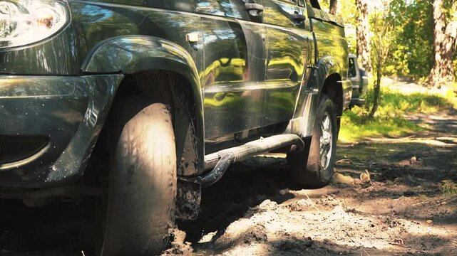 Close-up of a pickup truck backing out of a rut.
