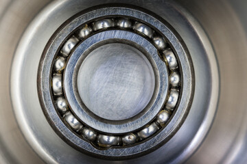 A central ball bearing in sharp focus, surrounded by metal that appears to rotate. A striking composition of technology, motion, and precision engineering..