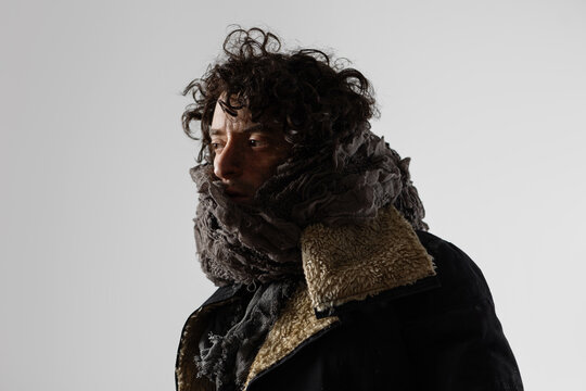 A dramatic hero from the post-apocalypse, a young man in mud and dirty clothes, wrapped in rags, expressive close-up portrait