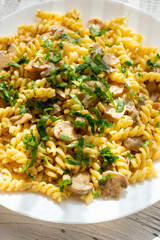 Italian pasta with creamy mushrooms and parsley on white plate in close-up