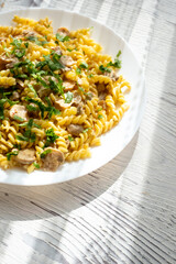 Italian pasta with creamy mushrooms and parsley on white plate in close-up