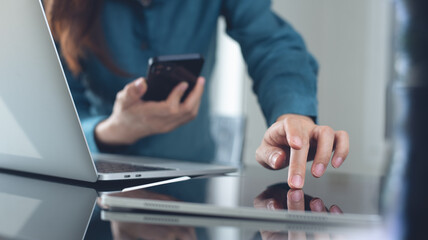 Business woman using digital tablet, mobile phone and laptop computer, working at modern office....