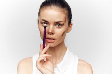 Professional young woman applying makeup with a brush, showcasing beauty techniques and confidence...