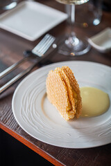 Delicious dessert with crispy wafers and creamy sauce served on a white plate showcasing culinary artistry and indulgence concept