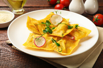 Delicious ravioli with microgreens and radish on wooden table, closeup