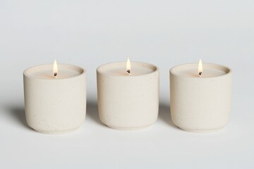 Three small, cream-colored candles, subtly speckled, burning brightly.  Simple, elegant design