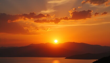 Vibrant sunset over tranquil mountains and water.