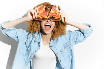Young woman joyfully holding pizza slices in front of her face, showcasing excitement and love for...