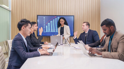 multiracial business people meeting,discussing and presentation with wind turbine and small solar panel in office room