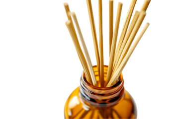 Reed diffuser sticks in amber bottle, fragrance aroma on white.