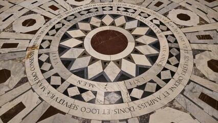 Florence, Italy - 3 January 2025. Circular marble floor tomb in the Florence Duomo with Latin...