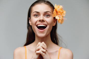 Happy young woman with flower in hair, expressing joy and excitement, perfect for lifestyle and...