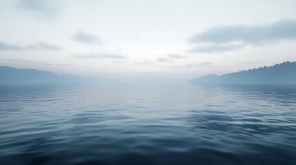 Fototapeta premium A serene, misty landscape over calm waters, with soft hues blending sky and lake, evoking tranquility and peacefulness.