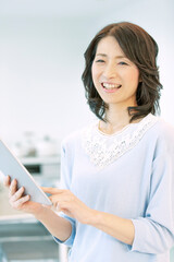 Fototapeta premium タブレットを操作する中年女性