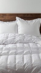 Snow-white bed linen is neatly laid out on two pillows lying on top of a duvet on a white background. Front view close-up photo. Suitable for mockups.