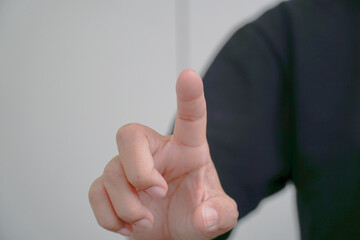 A hand with an index finger raised, suggesting a signal or instruction.
