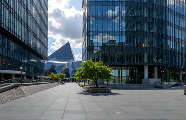 Obraz premium Modern Urban Architectural Scene with Glass Buildings and Public Space