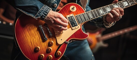 Obraz premium Close-up of a Musician's Hands Playing a Red Electric Guitar