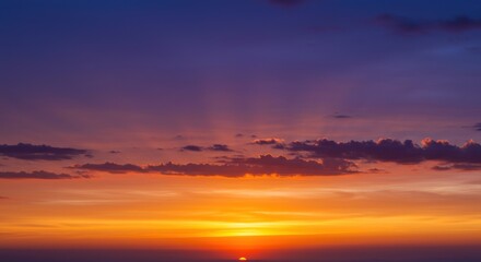 Obraz premium Dramatic sunset sky with orange and purple hues over a dark horizon.