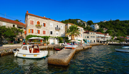 Fototapeta premium Waterfront promenade of Rose, a fishing village at the tip of the Luštica Peninsula on the eastern shore of the mouth of the bay of Kotor along the coast of the Adriatic Sea in Montenegro