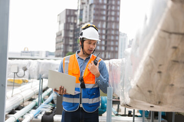 Engineer, Plumber, Building utilities on rooftop. Male engineer checks, repair or maintenance of...