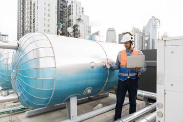 Engineer, Plumber, Building utilities on rooftop. Male engineer checks, repair or maintenance of building utilities system on rooftop of building.  Male plumber working at sewer pipes area at rooftop