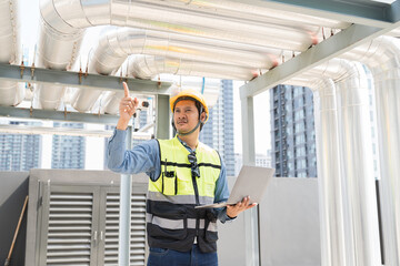 Engineer, Plumber, Building utilities on rooftop. Male engineer checks, repair or maintenance of building utilities system on rooftop of building.  Male plumber working at sewer pipes area at rooftop