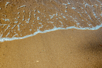 foam waves on the beach sand. Natural background