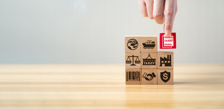 Tariff and international trade concept with wooden blocks showing import, export, shipping, factory, agreement, and tax symbols. Global commerce, customs duty, and economic regulation strategy.