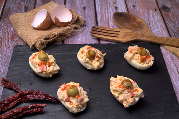 Stuffed eggs with olives on slate stone