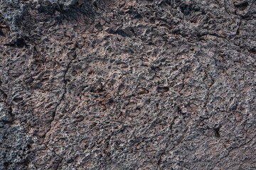 Nahaufnahme einer grau-schwarzen Lava-Textur auf dem Boden. Porös, rissig und steinern, ideal als...