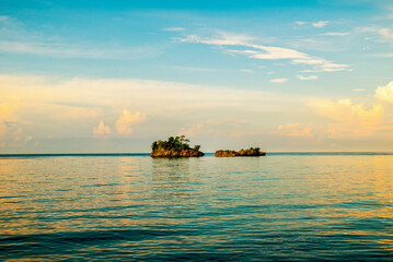 Natural view of small islands from the middle of the ocean at sunset