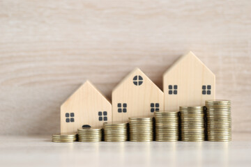 Mortgage,Model house and stack of coins money on wooden background,Business investment and real estate concept