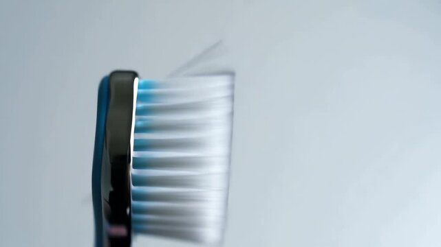 Close-up, slow-motion view captures soft bristles of a prophy brush rapidly shaking, highlighting the subtle movement against a blurred background