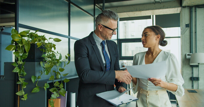 Businessman and woman walking in modern office